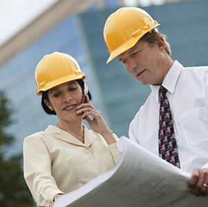 Two engineers speaking with hard hats on