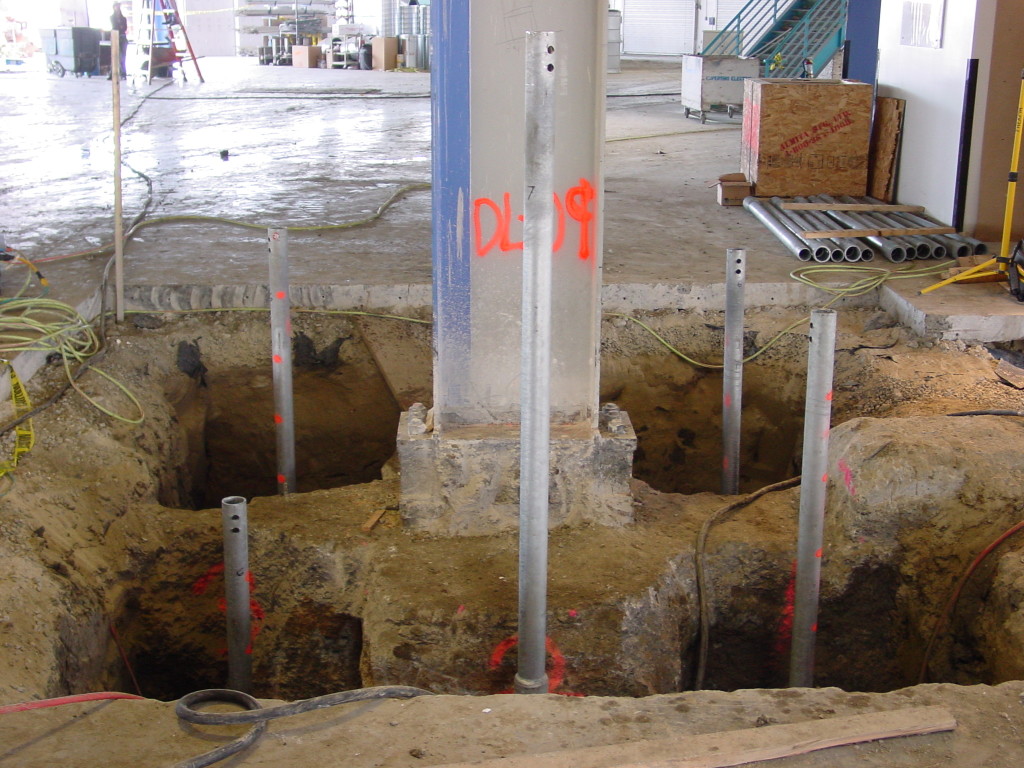 Grouted helical tie-down installation around existing column