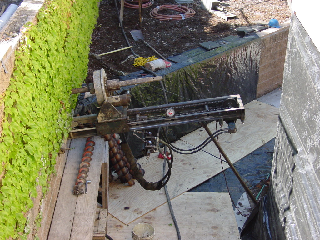 Drilling tieback for additional support for existing retaining wall