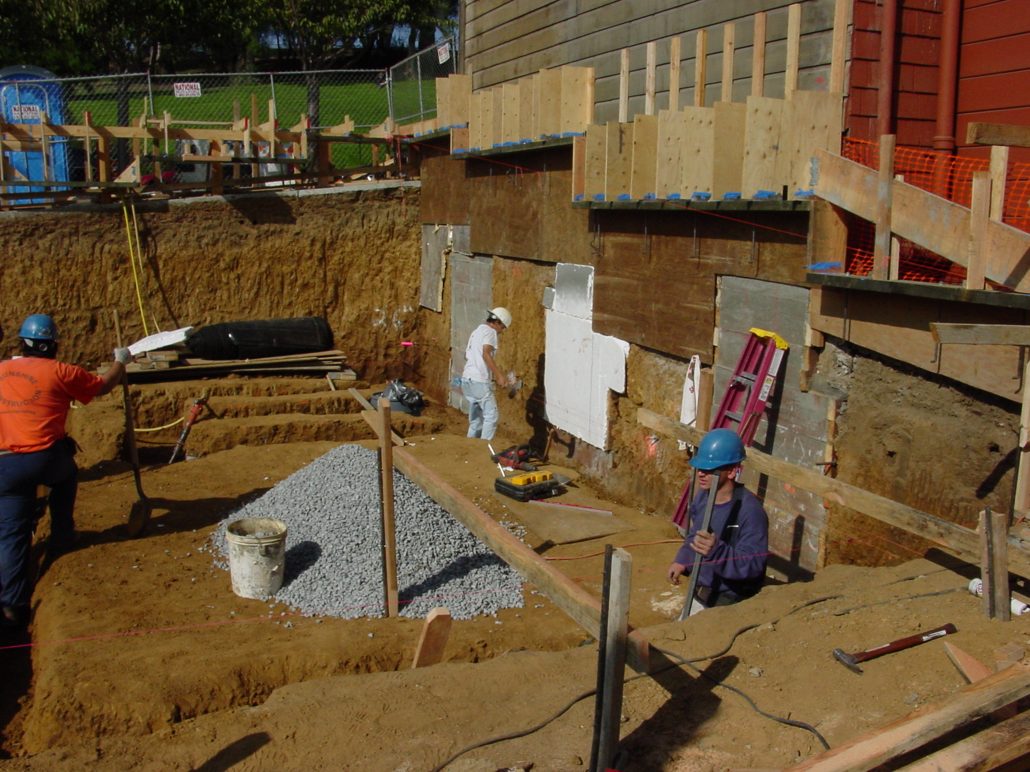 Excavation complete with hand-dug underpinning piers under neighbor’s foundation exposed
